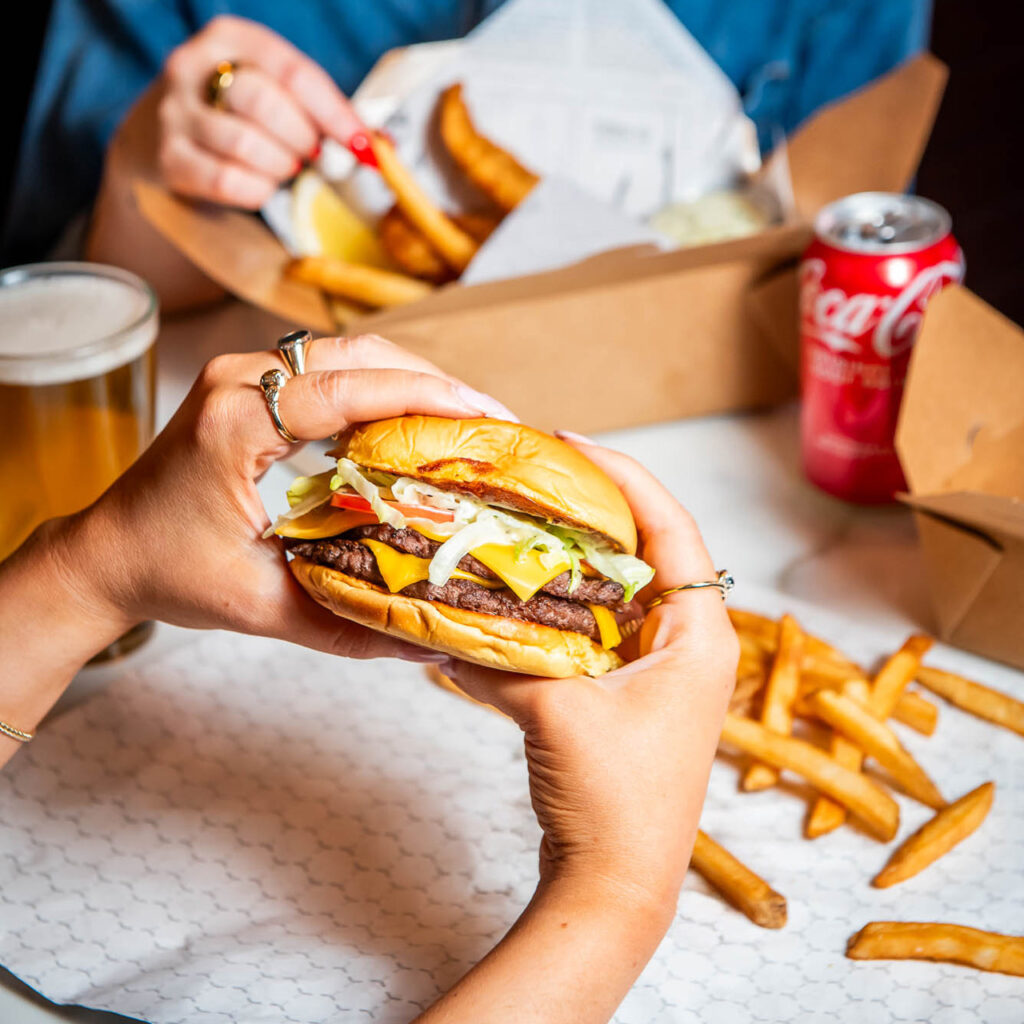 swanky burger held with two hands